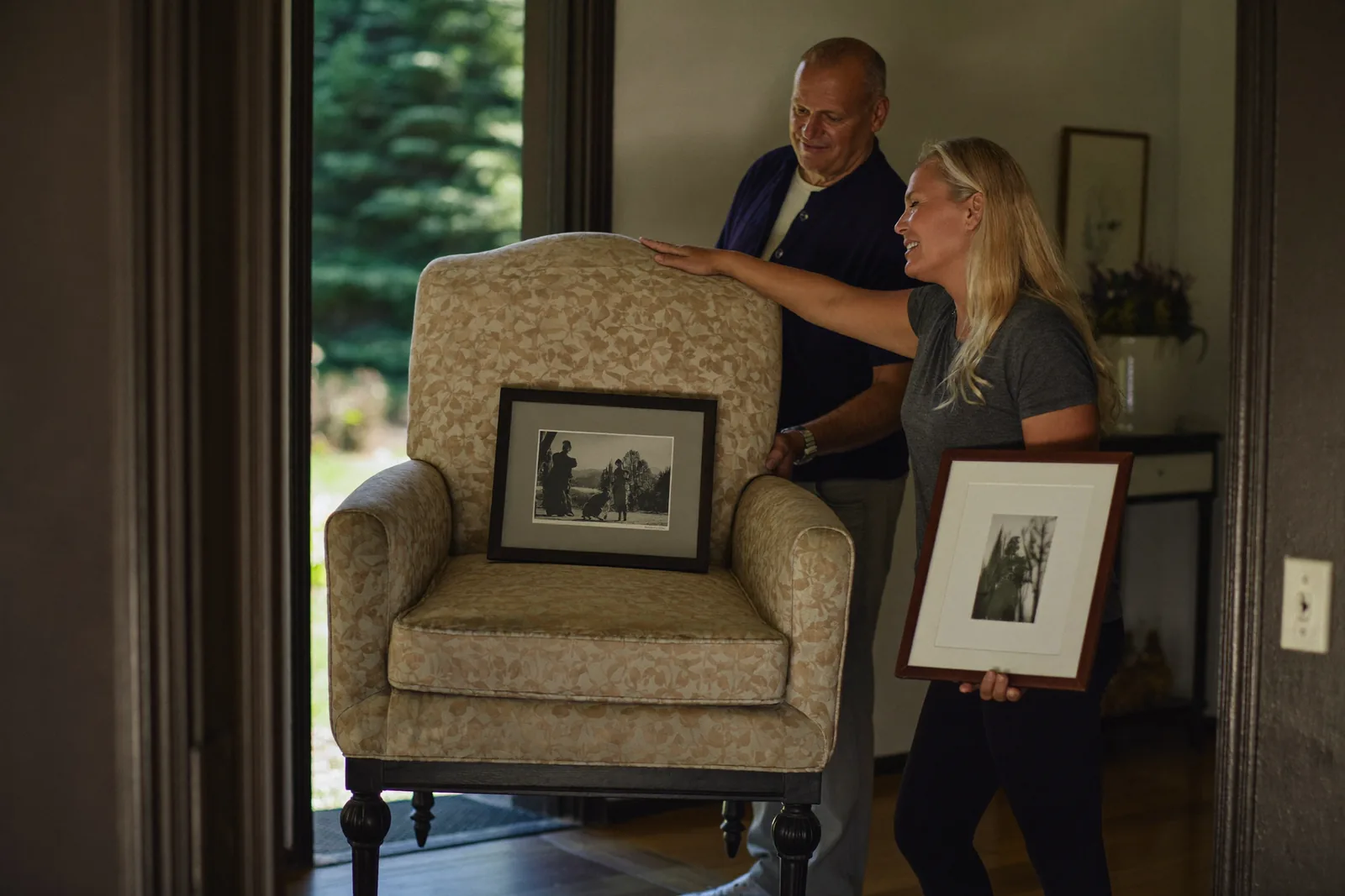 Movers carrying a favorite armchair into a sunny senior apartment