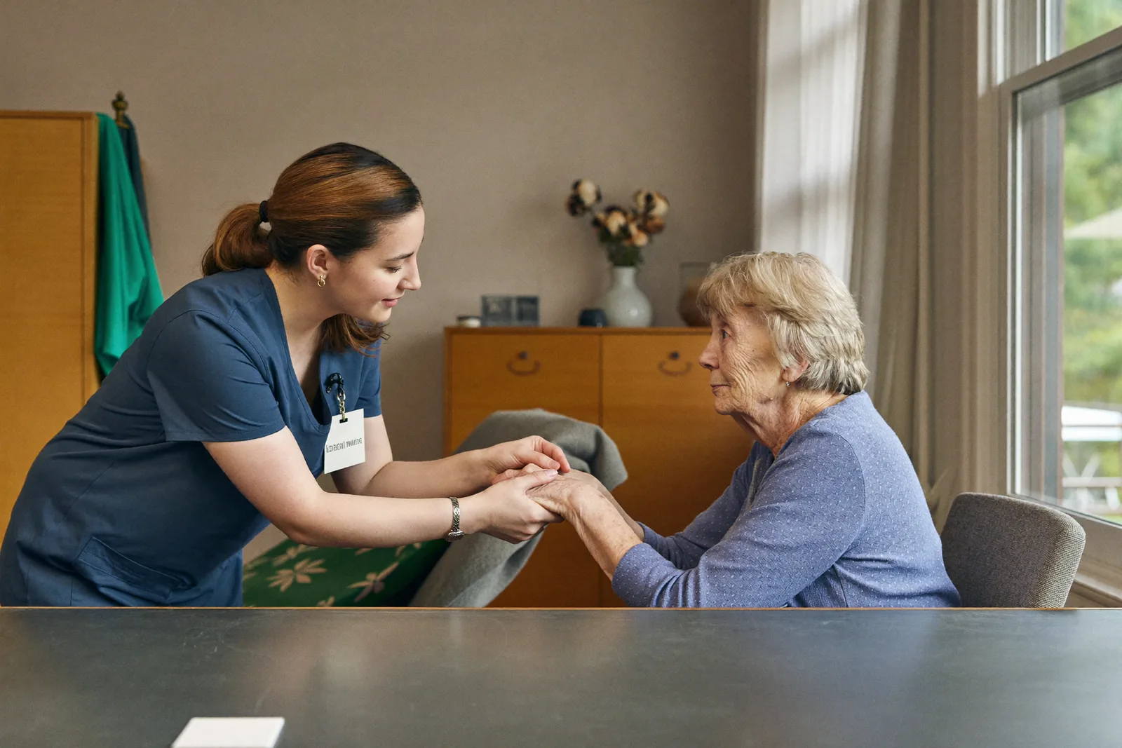 Caregiver holding hands with a resident in a calm activity room
