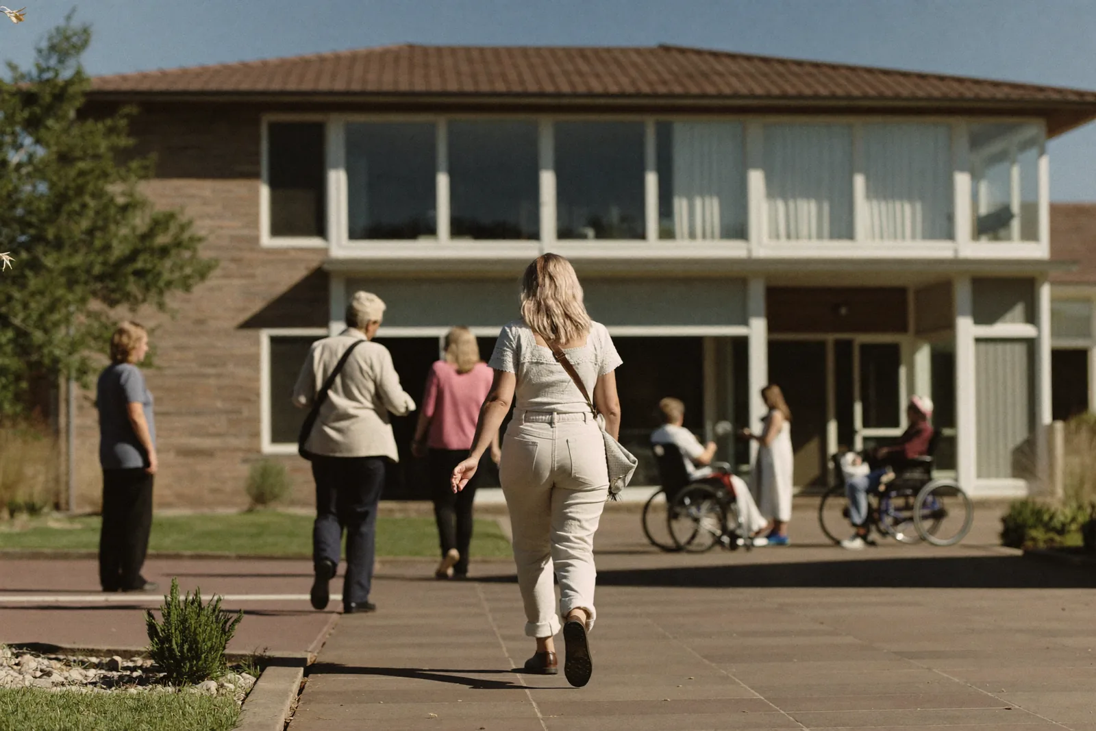 Adult daughter walking a community courtyard on a second visit