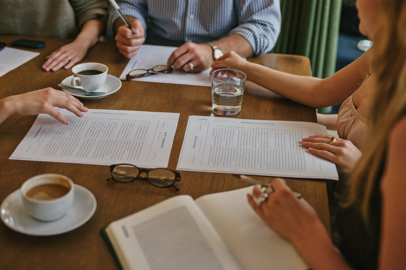 Family comparing three completed rating sheets at a dining table