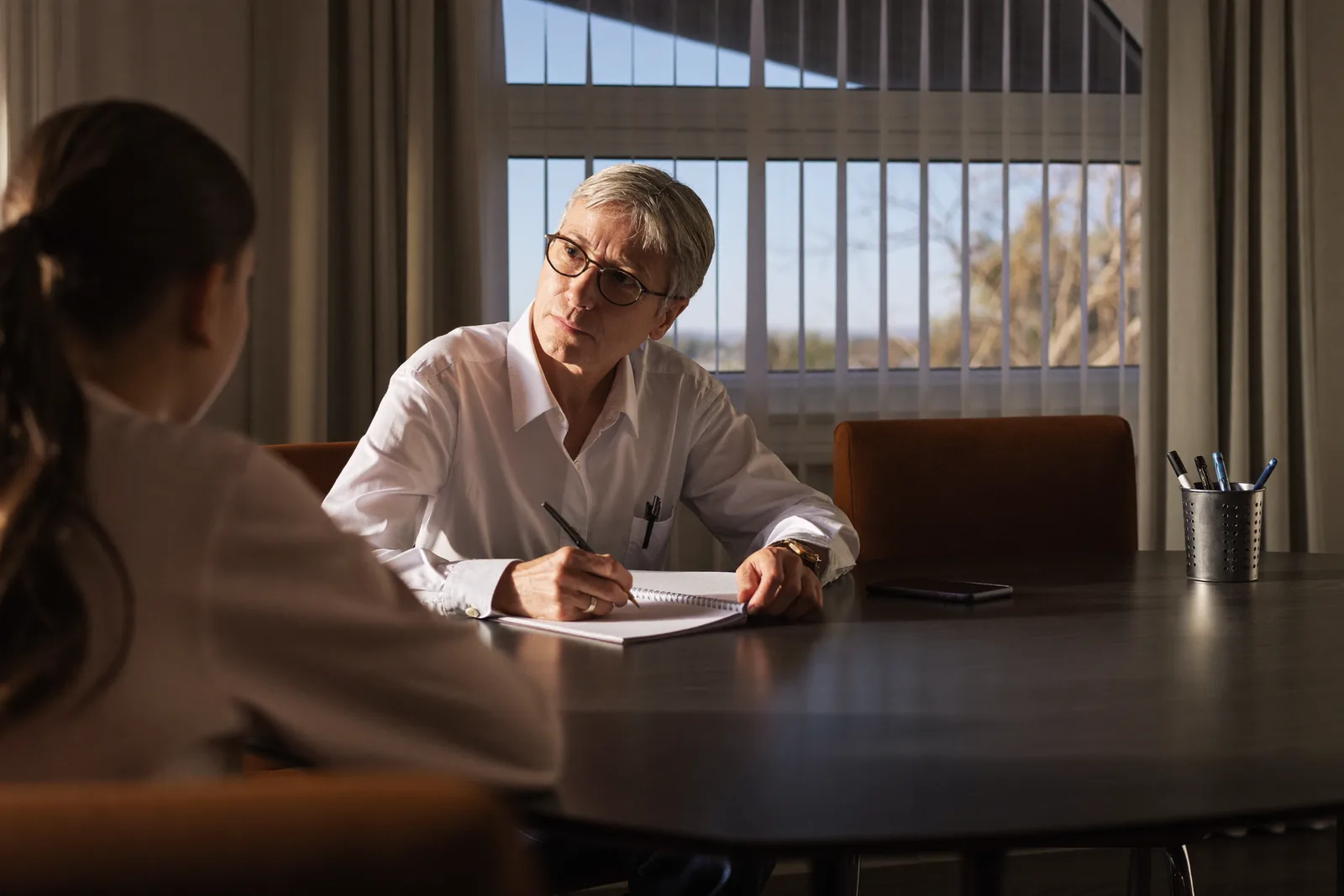 Advisor listening to an adult daughter across a consultation table