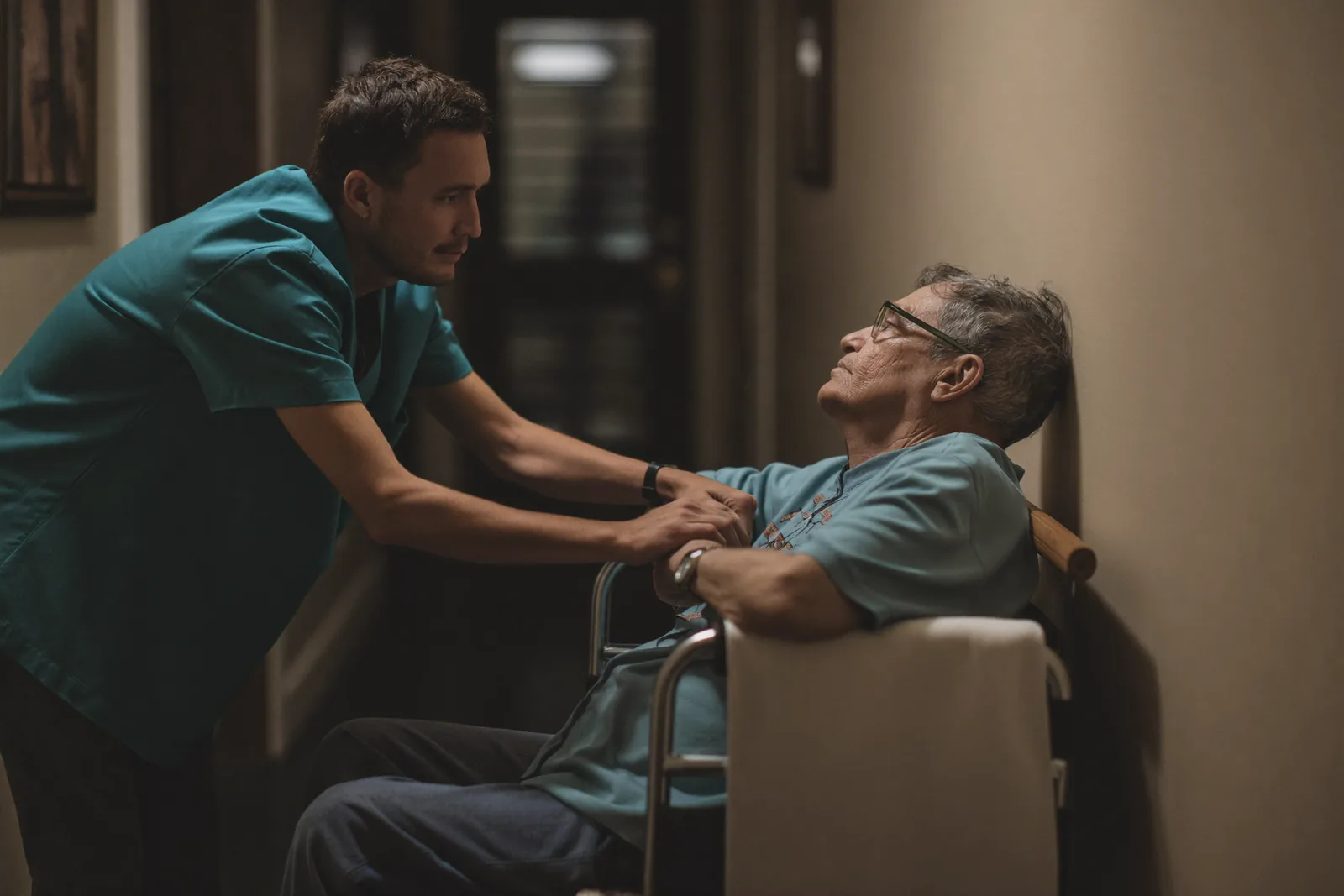 Caregiver checking on a resident awake at night in a dim hallway