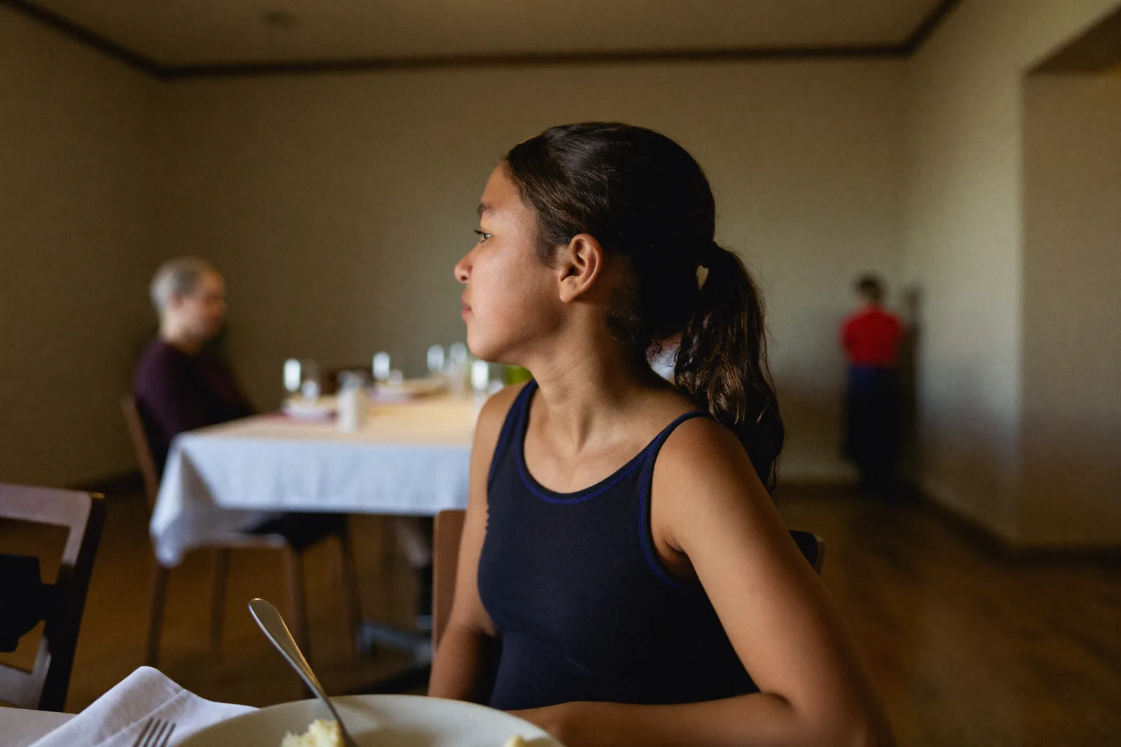 Adult daughter observing a sparse dining room at mealtime