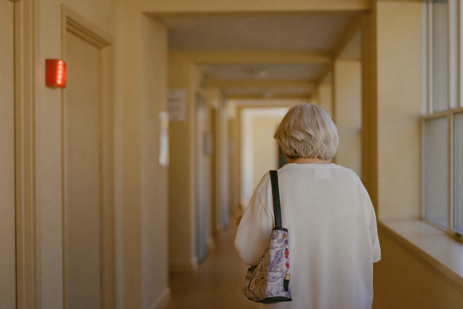 Unattended call light glowing in an empty assisted living hallway