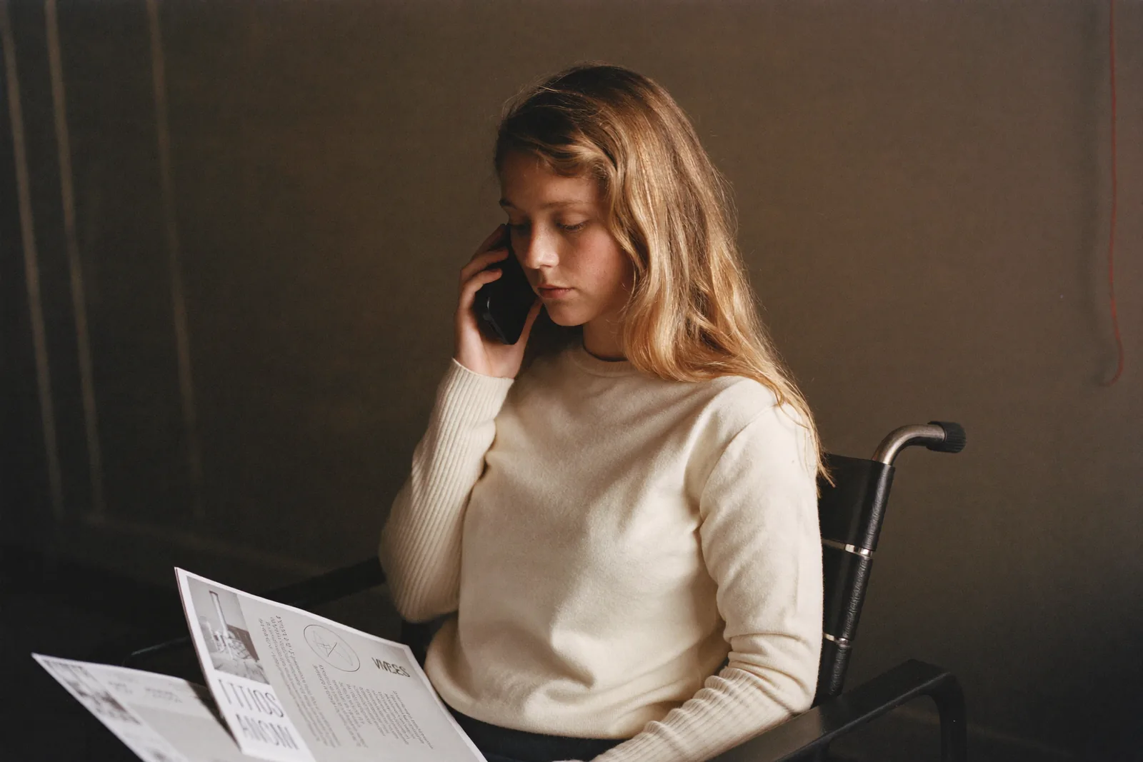 Adult daughter checking availability by phone with two brochures