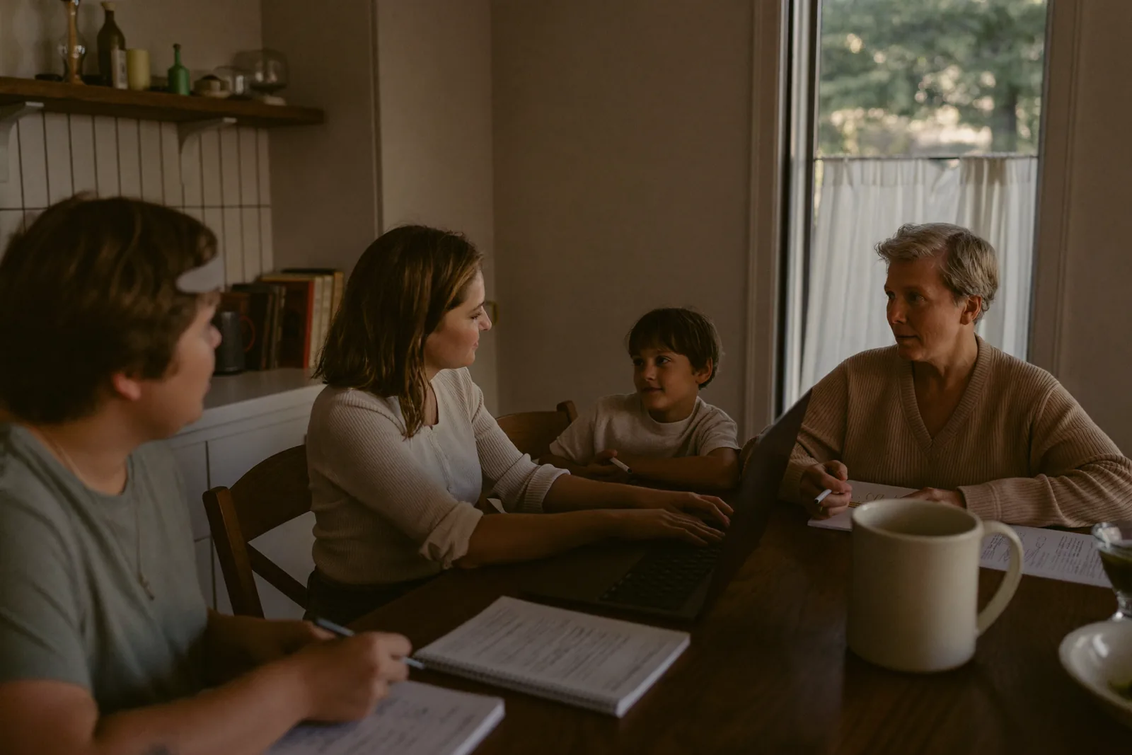 Three adult siblings discussing options around a dining table