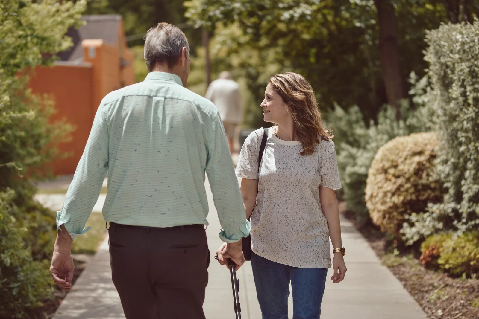 Father and daughter walking together on a quiet sidewalk
